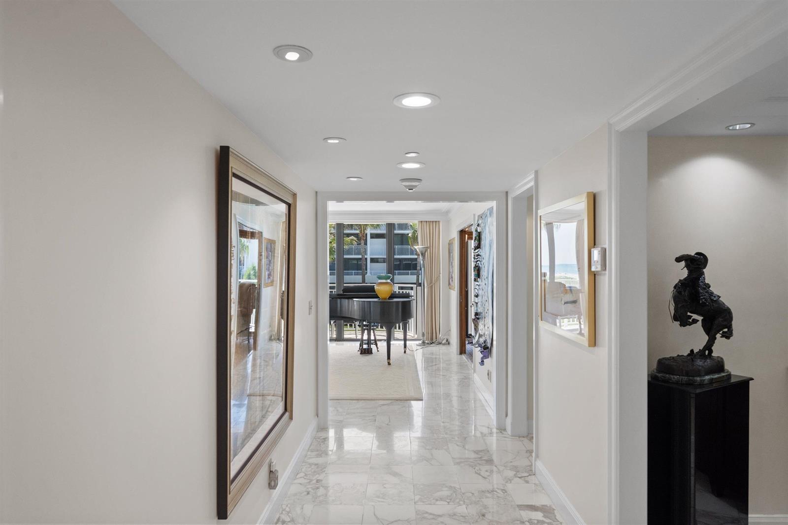 A marble-floored hallway leads to a living area featuring a grand piano and balcony view — 2580 S Ocean Boulevard, Palm Beach FL 33480, PALM BEACH, FL