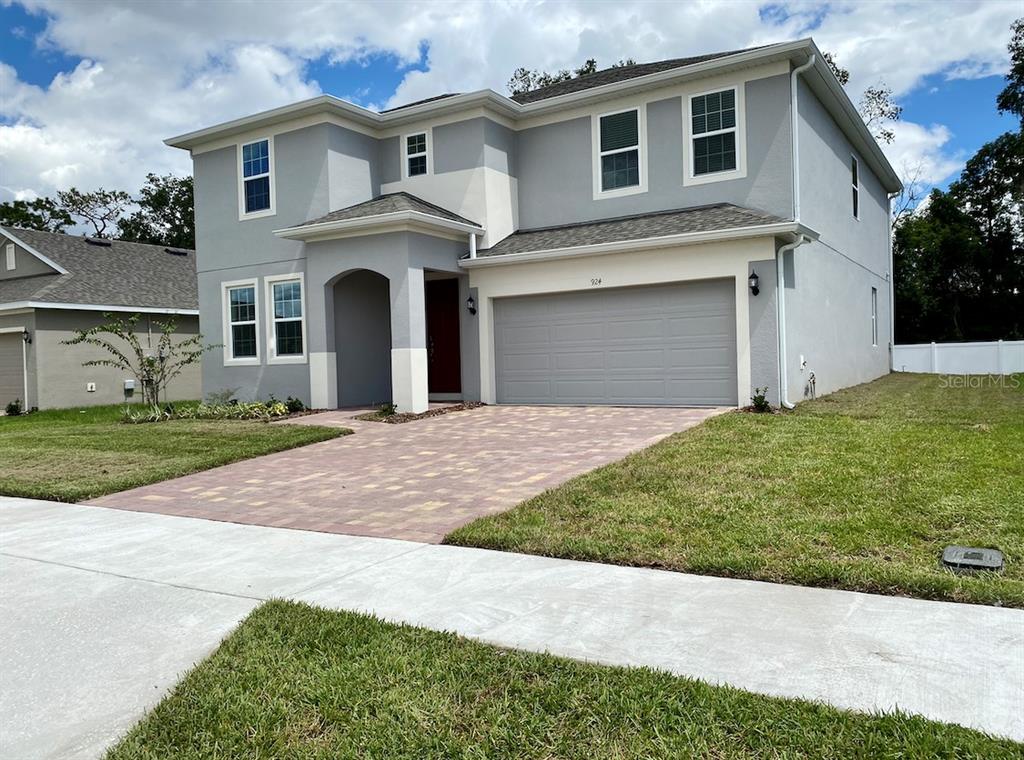 A two-story gray house with a two-car garage and a paved driveway — 924 AVENAL LANE, DAVENPORT, FL