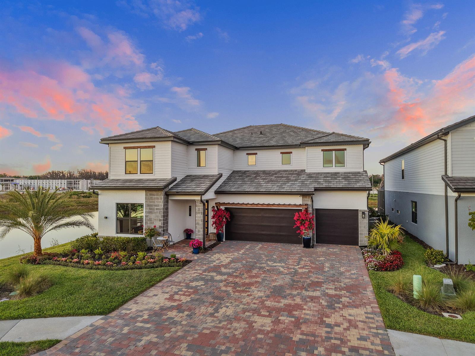 A two-story house with a brick paver driveway, a three-car garage, and a landscaped yard — 4107 Traditions Drive, Ave Maria FL 34142, AVE MARIA, FL