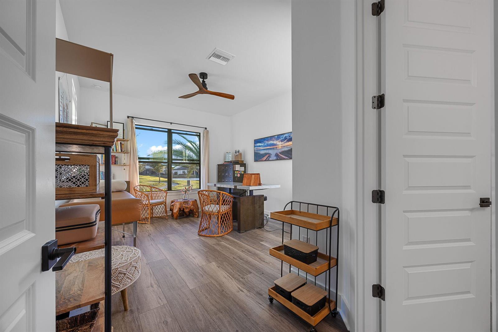 A home office with wood-look flooring, a ceiling fan, and a window overlooking a lawn — 4107 Traditions Drive, Ave Maria FL 34142, AVE MARIA, FL