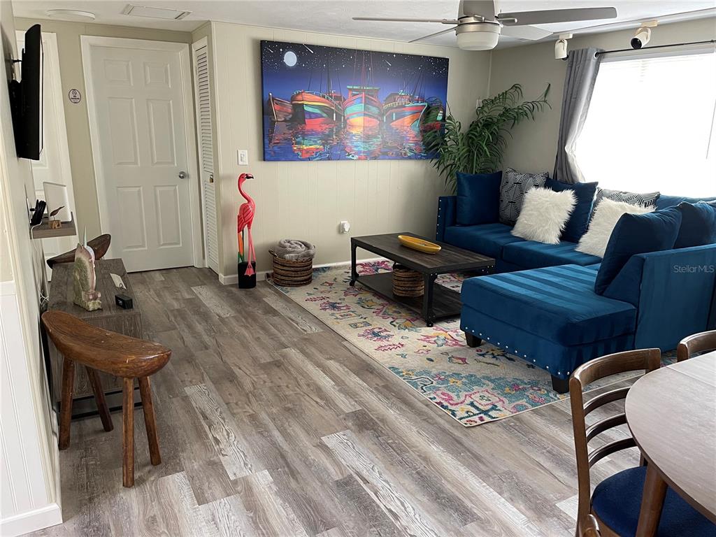 A living room features a blue sectional sofa, a patterned rug, and a boat painting — 50 EUCLID AVENUE, ENGLEWOOD, FL