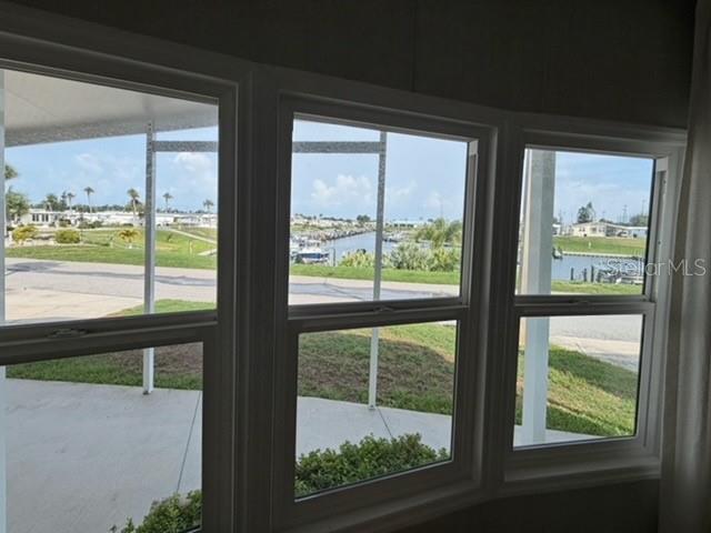 A view of a canal and neighborhood through three large windows in a room — 815 S WATERWAY, VENICE, FL