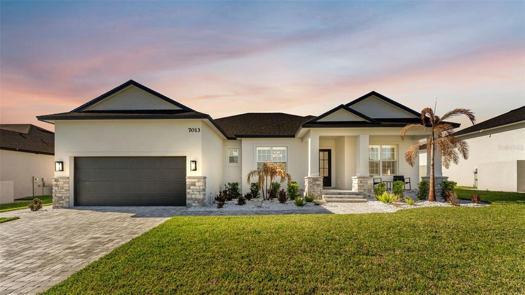 A single-story house with a two-car garage, stone accents, and a paved driveway — 7013 BENTRIDGE DRIVE, LAKELAND, FL