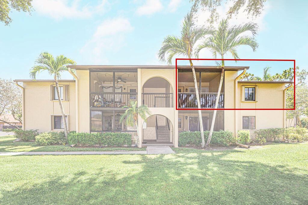 The exterior of a two-story apartment building features a screened balcony on the upper level — 539 Shady Pine Way # B2, FL 33415, FL