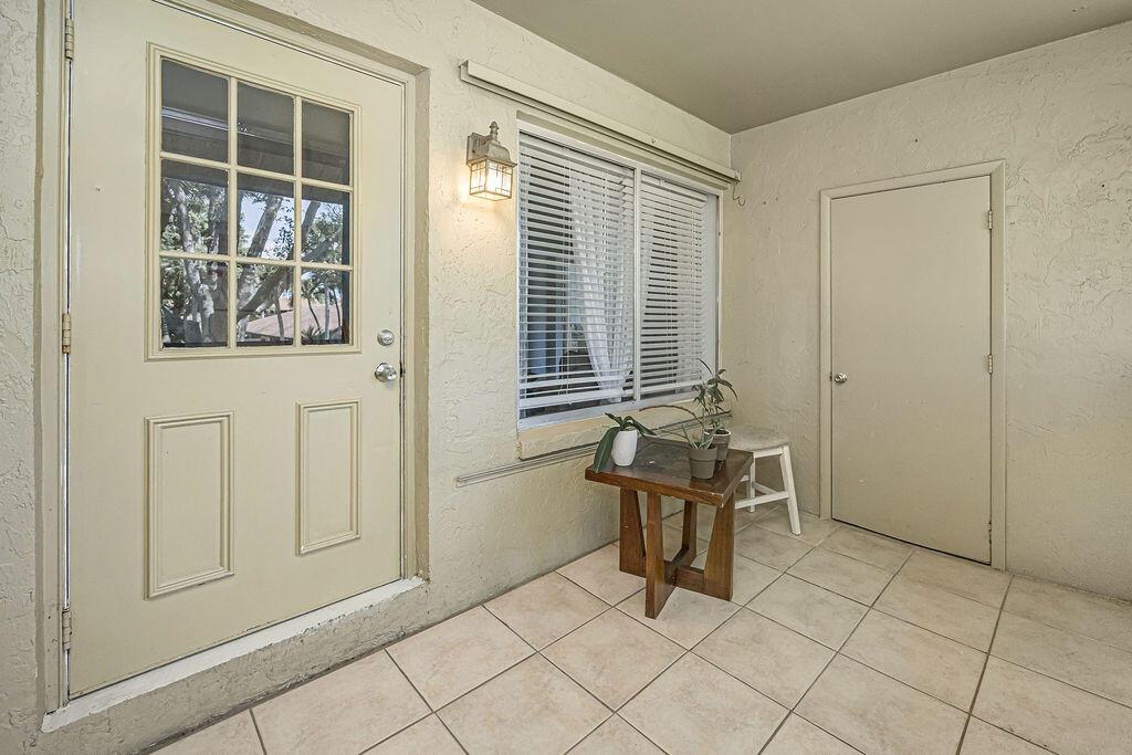 A tiled entryway features a white door with glass panes, a window, and a table — 539 Shady Pine Way # B2, FL 33415, FL