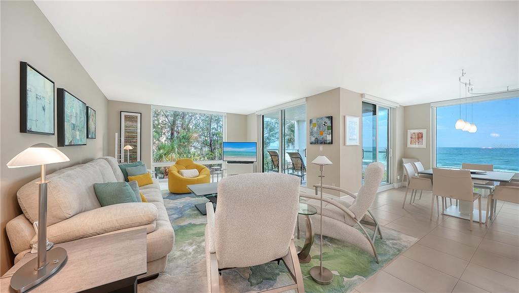 A living and dining area features a beige sofa, ocean views, and tile flooring — 2425 GULF OF MEXICO DRIVE UNIT 3A, LONGBOAT KEY, FL