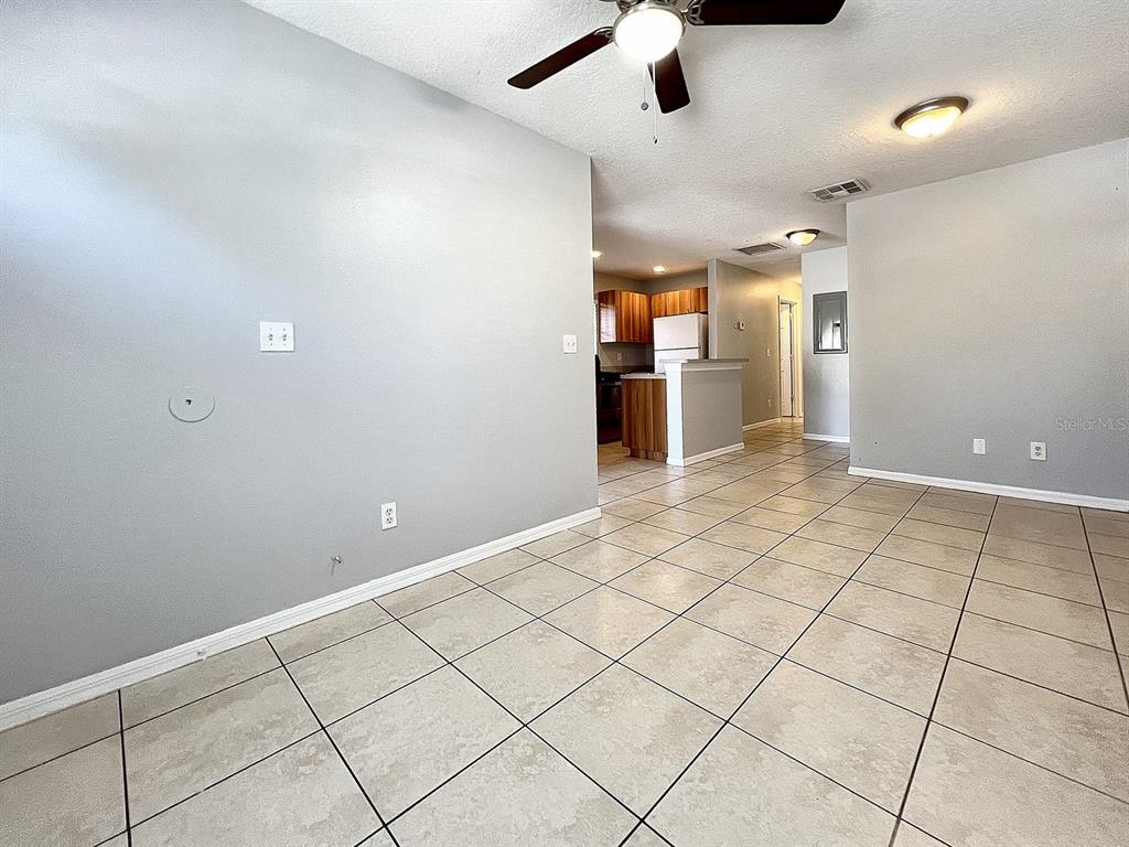 A living area with light gray walls and tiled floors leads to a kitchen — 2407 E 17TH AVENUE UNIT A, TAMPA, FL