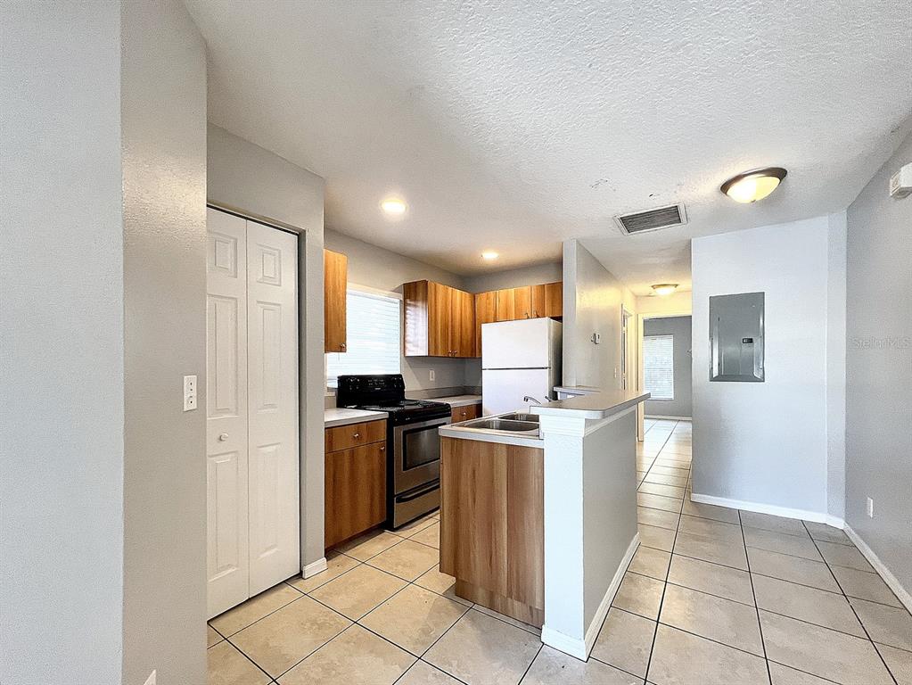 A kitchen with wood cabinets, stainless steel appliances, and tile flooring — 2407 E 17TH AVENUE UNIT A, TAMPA, FL