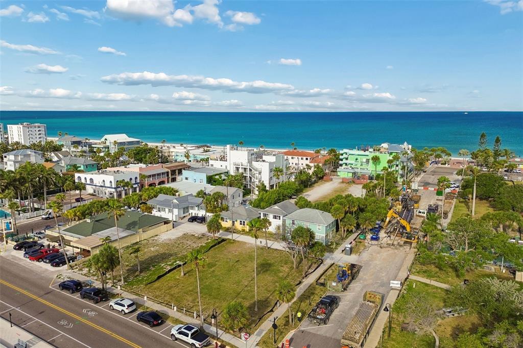 An aerial view shows a coastal neighborhood with houses, palm trees, and road construction — 808 PASS A GRILLE WAY, ST PETE BEACH, FL