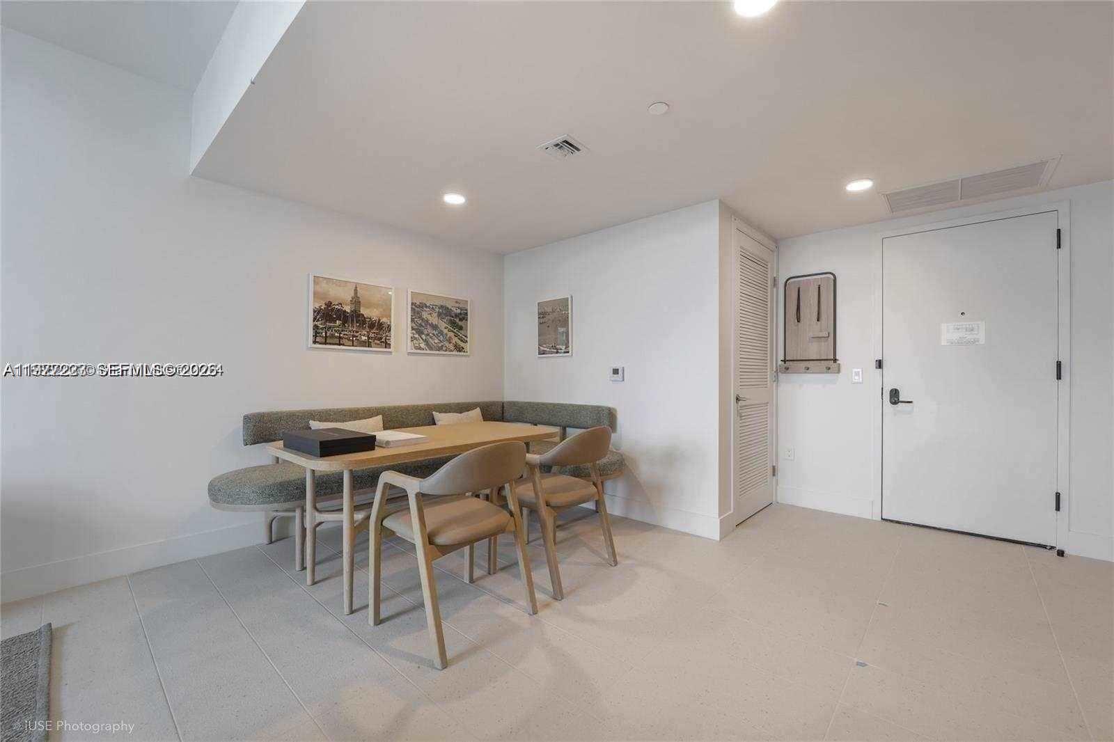 A dining area features a corner banquette, a wooden table, and two chairs — 159 NE 6th St # 4113, Miami FL 33132, MIAMI, FL