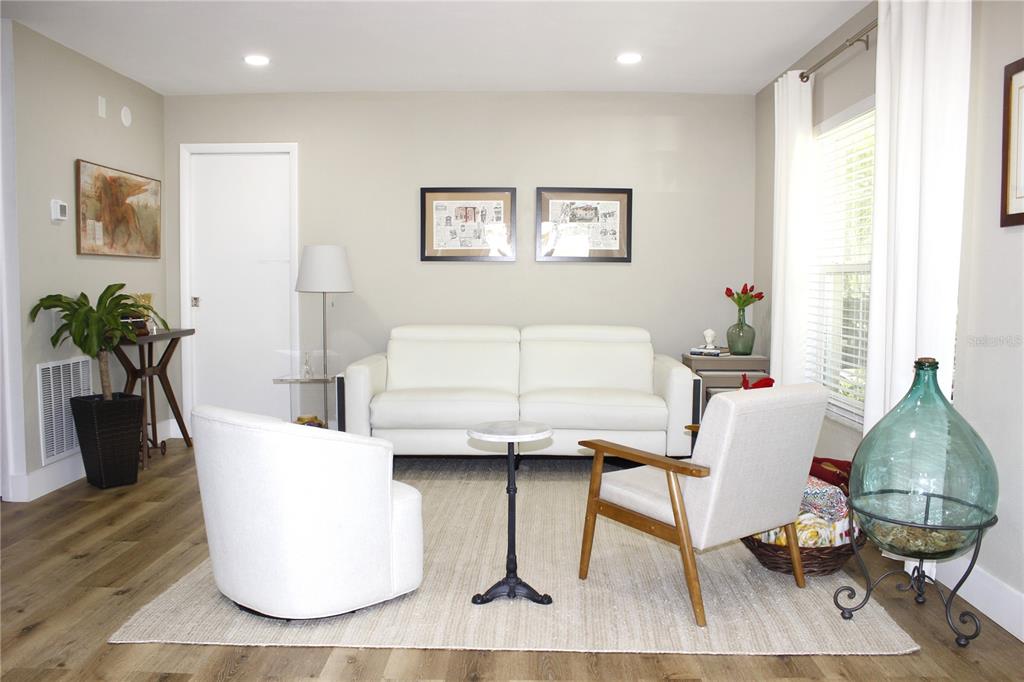 A living room features a white sofa, two armchairs, a small side table, and artwork — 11861 RAINTREE DRIVE UNIT 65, TAMPA, FL