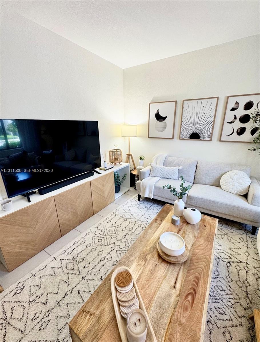 A living room features a light wood media console, a grey sofa, and a coffee table — 21443 NE 2nd Path # 21443, Miami FL 33179, MIAMI, FL