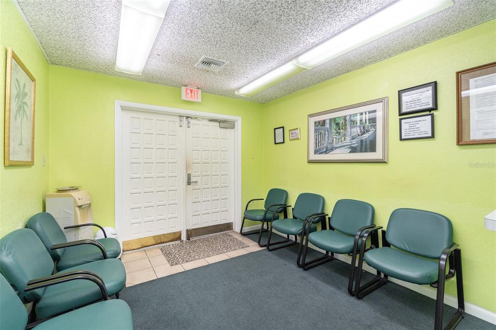 A waiting room with lime green walls, teal chairs, and a double exit door — 6005 SILVER STAR ROAD, ORLANDO, FL
