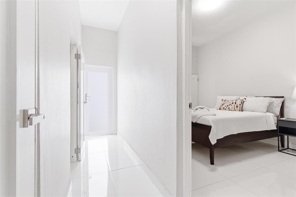 A white hallway with tile flooring leads to a bedroom with a dark wood bed — 56 CALLE F KRUG CONDADO UNIT 4, SAN JUAN, PR