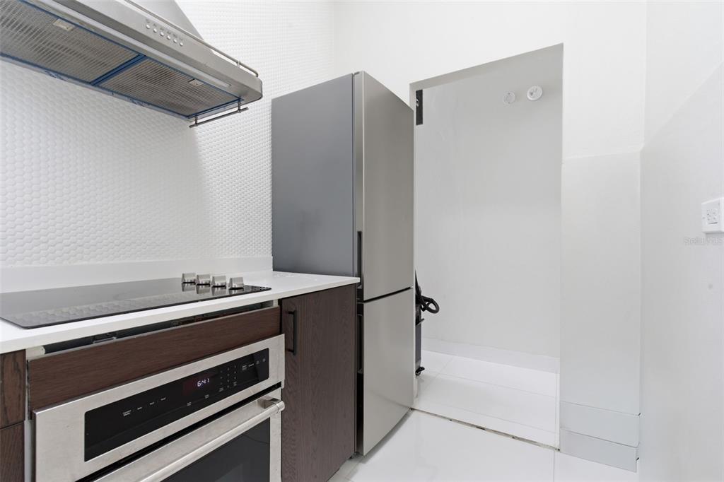A modern kitchen features a stainless steel refrigerator, built-in oven, and white hexagonal tile backsplash — 56 CALLE F KRUG CONDADO UNIT 4, SAN JUAN, PR