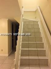 A kitchen features white cabinets, a stainless steel refrigerator, and a white electric range — 655 W 68th St # 4, Hialeah FL 33014, HIALEAH, FL