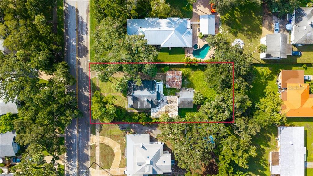 An aerial view shows a residential property outlined in red, featuring a house and trees — 1116 MAGNOLIA STREET, NEW SMYRNA BEACH, FL