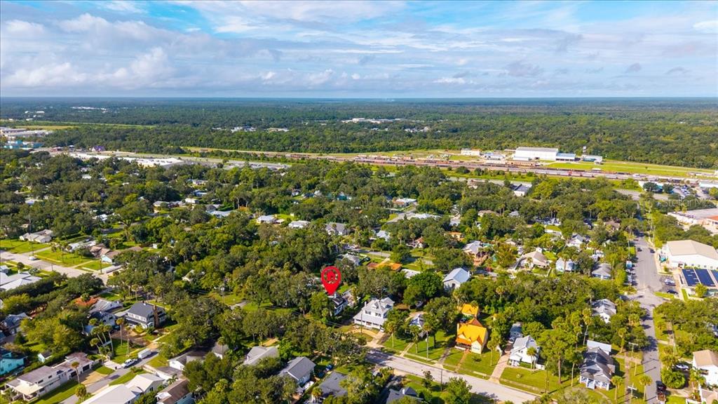 An aerial view shows a residential neighborhood with a red pin marking a specific house — 1116 MAGNOLIA STREET, NEW SMYRNA BEACH, FL
