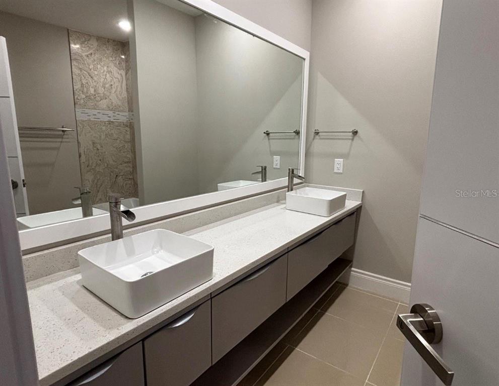 A modern bathroom features a double vanity with vessel sinks and a large wall mirror — 1915 GREENBRIAR TERRACE, DAVENPORT, FL