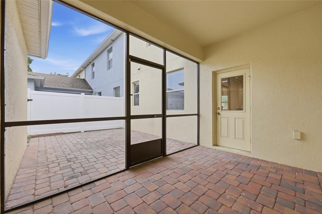 A screened-in patio with brick pavers and a door leading into the house — 1351 VASEY ROAD, APOPKA, FL