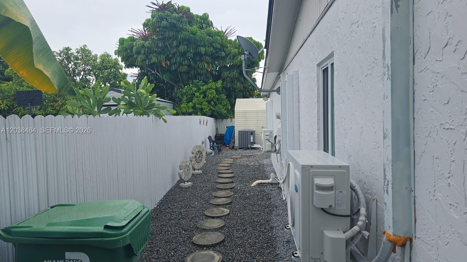 A narrow side yard features a gravel path, stepping stones, and an exterior HVAC unit — 13220 SW 66th St # A, Miami FL 33183, MIAMI, FL