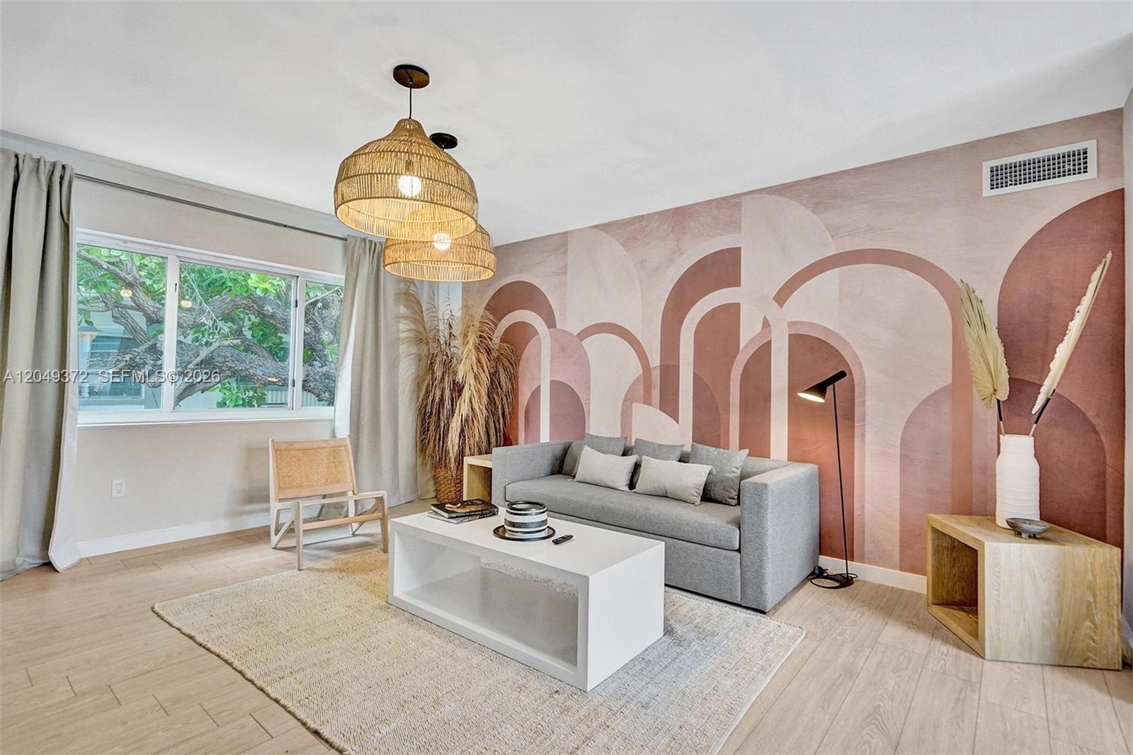 A living room features a geometric mural, a grey sofa, and two woven pendant lights — 1415 16th St # 2, Miami Beach FL 33139, MIAMI BEACH, FL