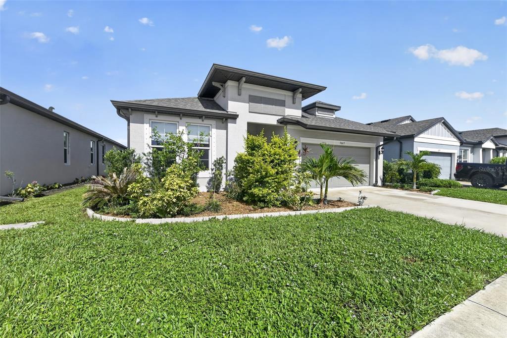 A single-story suburban house with a gray exterior, a two-car garage, and a landscaped yard — 3663 QUIET DRIVE, SARASOTA, FL