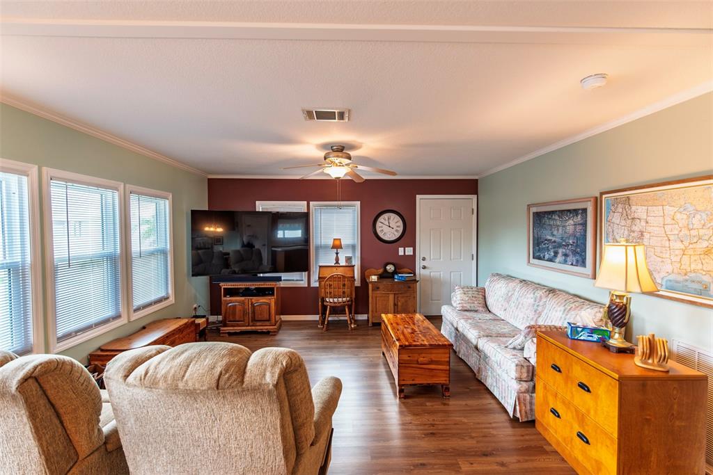 A living room features light green walls, a dark red accent wall, and wood-look flooring — 21 BRINK AVENUE, PUNTA GORDA, FL