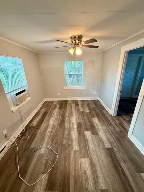 An empty room features wood-look vinyl flooring, a ceiling fan, and a window air conditioner — 908 BEVERLY AVENUE UNIT F, LARGO, FL