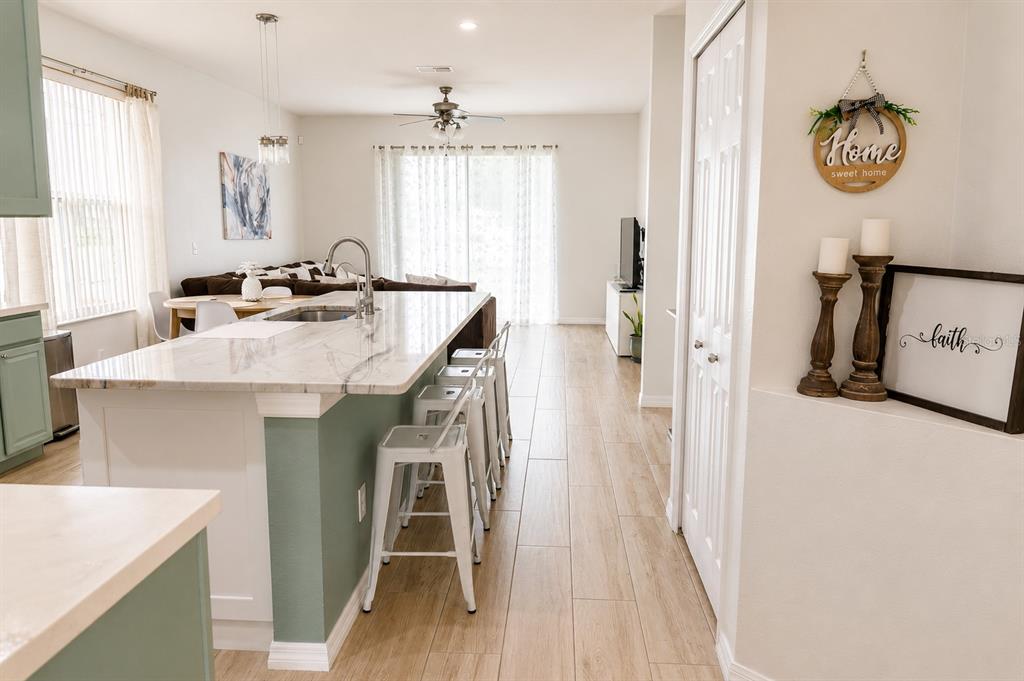 A kitchen island with bar seating sits in an open-concept home with tile flooring — 10118 CYPRESS KNEE CIRCLE, ORLANDO, FL