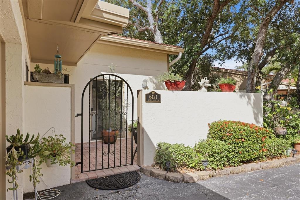 A single-story house with a two-car garage, a paved driveway, and a front courtyard wall — 6421 SUN EAGLE LANE, BRADENTON, FL