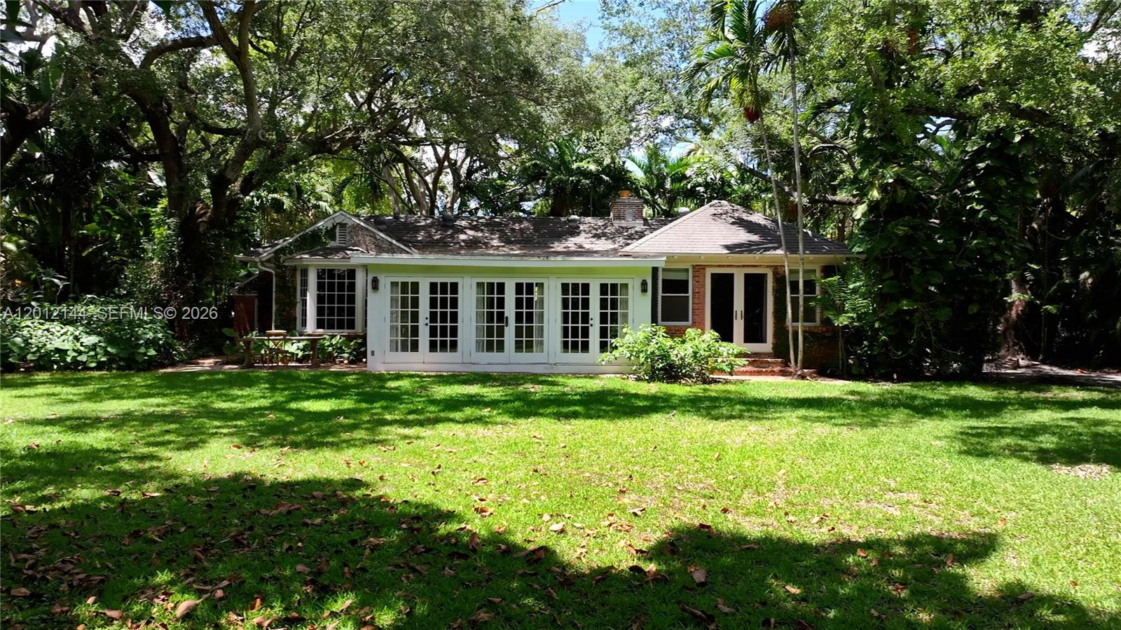 The exterior of a single-story house features white French doors and a large lawn — 530 Melaleuca Ln, Miami FL 33137, MIAMI, FL