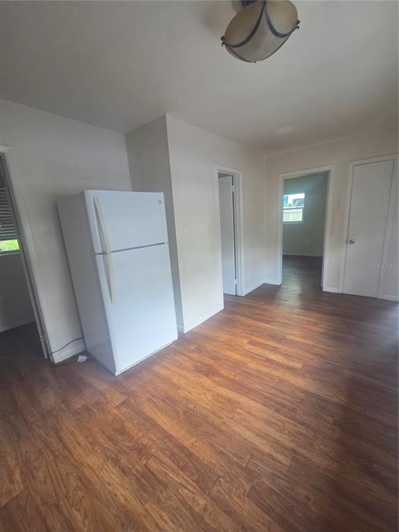 A kitchen area features a white refrigerator, wood-look flooring, and doorways leading to other rooms — 572 BELL, BROOKSVILLE, FL