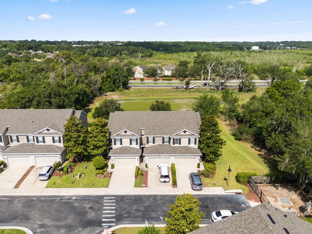 An aerial view shows two multi-story townhomes with attached garages and driveways — 1512 GROUNDSEL LANE, OCOEE, FL