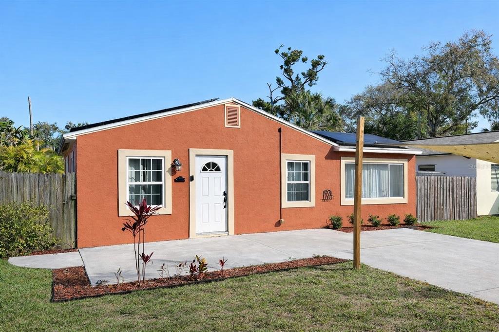 A single-story orange stucco house with a white front door and a concrete driveway — 5613 19TH AVENUE S, GULFPORT, FL