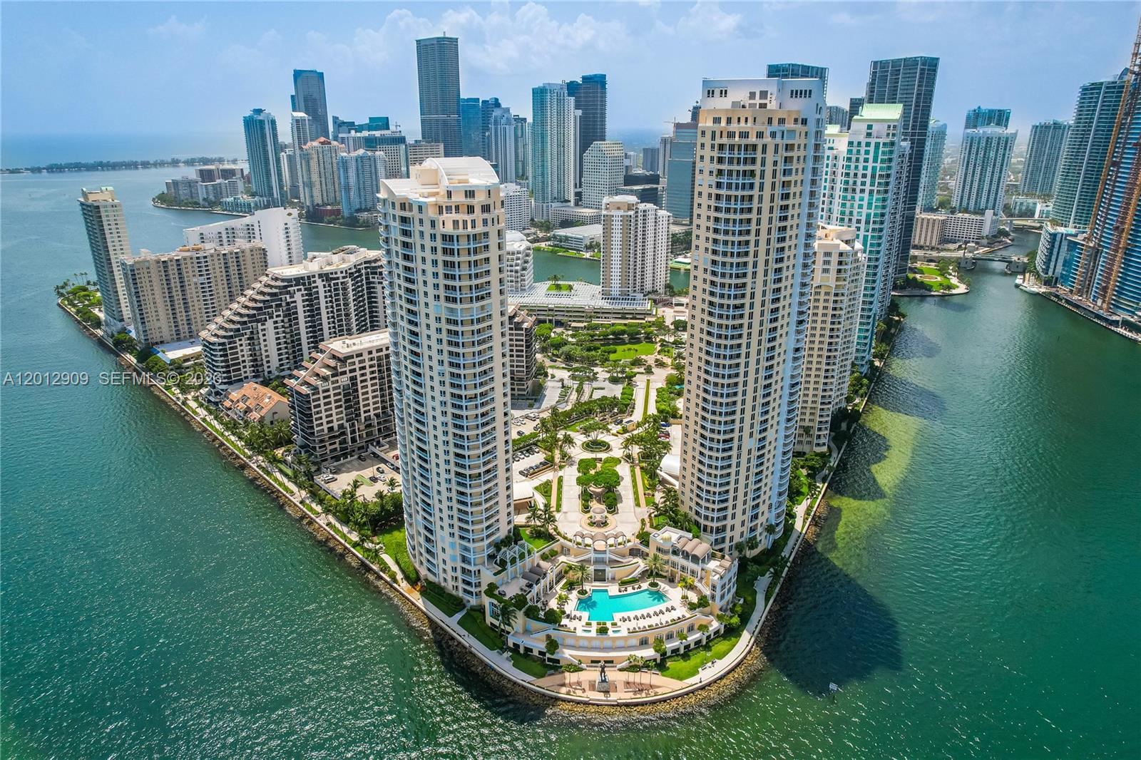 An aerial view of two tall residential towers surrounded by water and a landscaped courtyard — 848 Brickell Key Dr # 1903, Miami FL 33131, MIAMI, FL