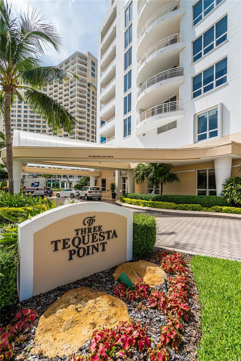 The exterior of the Three Tequesta Point residential building features a landscaped entrance and driveway — 848 Brickell Key Dr # 1903, Miami FL 33131, MIAMI, FL