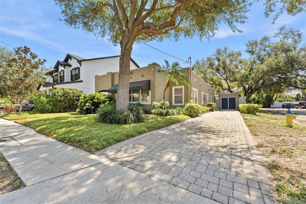 A two-story house with a paved driveway, a large tree, and a tan exterior — 1618 S ARRAWANA AVENUE, TAMPA, FL