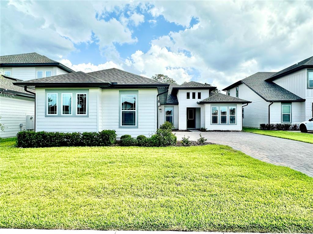 A single-story white house with a gray roof, a paved driveway, and a green lawn — 17552 LAKE STAR ROAD, WINTER GARDEN, FL
