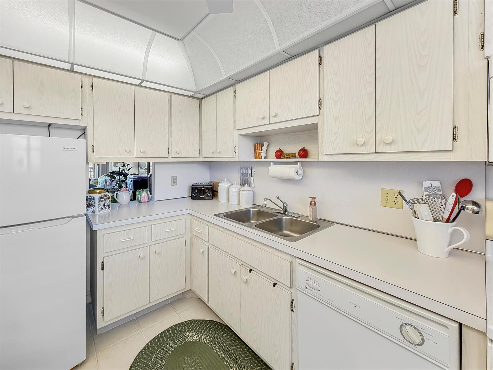 A kitchen features light wood-grain cabinets, white appliances, a double sink, and a white countertop — 555 NW 4th Avenue # 401, Boca Raton FL 33432, BOCA RATON, FL