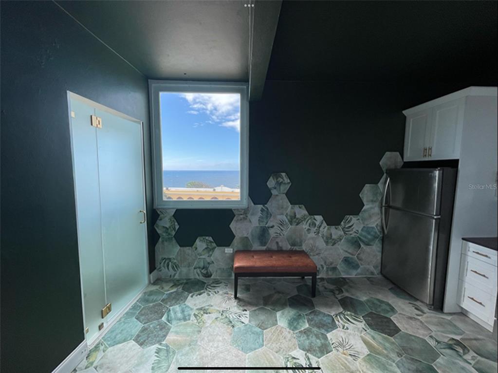 A kitchen area features dark walls, hexagonal floor and wall tiles, a bench, and ocean views — 9 DEL MERCADO UNIT 4, SAN JUAN, PR