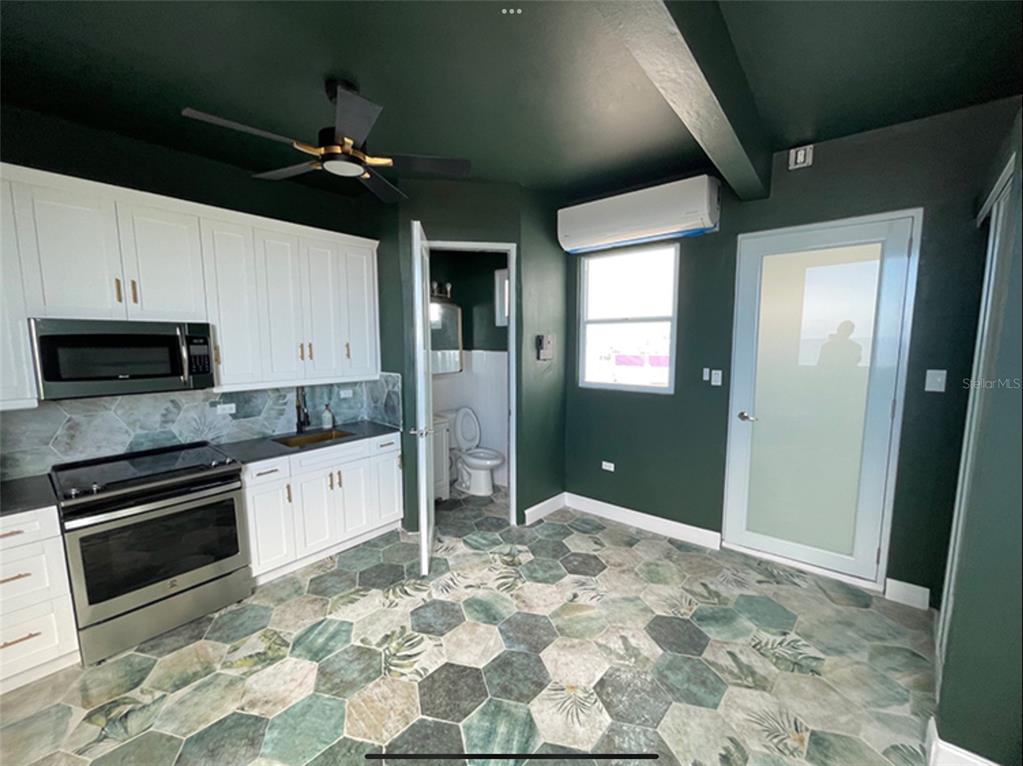 A kitchen with white cabinets, dark green walls, and patterned hexagonal floor tiles — 9 DEL MERCADO UNIT 4, SAN JUAN, PR