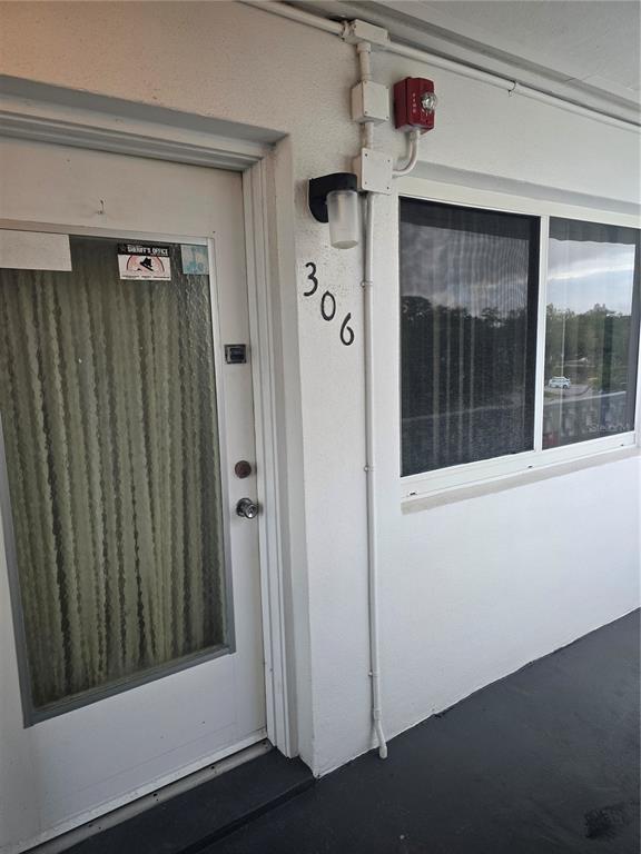 An exterior view of a white apartment door numbered 306 with a window and light — 8126 112TH STREET UNIT 306, SEMINOLE, FL