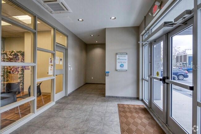 A tiled entryway features glass-walled offices on the left and a glass door entrance — 310 S MACDILL AVENUE, TAMPA, FL
