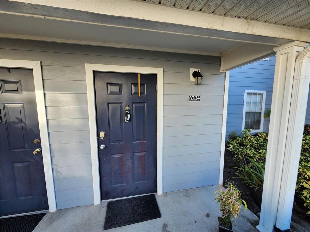A dark blue front door with a house number sits under a covered porch — 14905 Pleasant Bay Lane # 6204, Naples FL 34119, NAPLES, FL