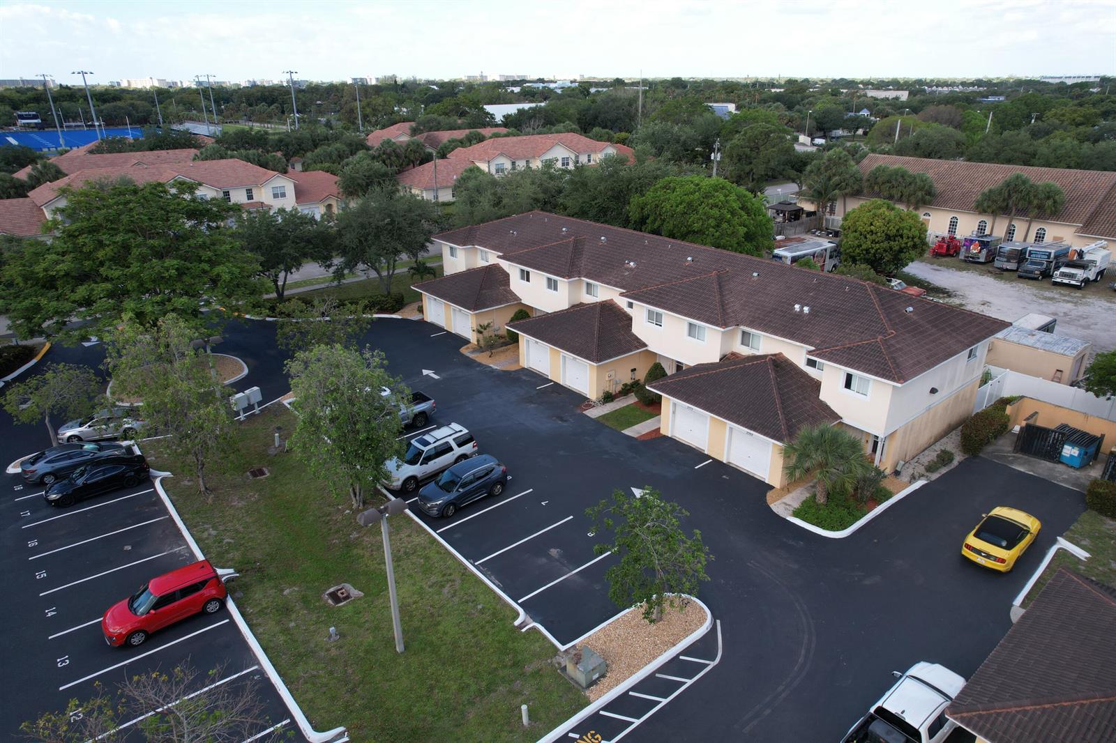 An aerial view shows a multi-unit residential building with a parking lot and several vehicles — 2769 NW 13th Street # 6, Pompano Beach FL 33069, POMPANO BEACH, FL