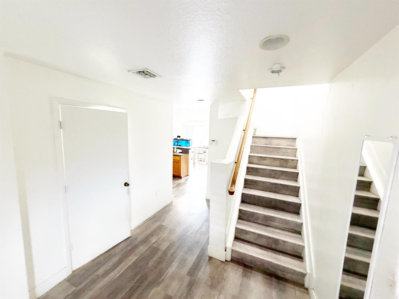 A bright entryway features wood-look flooring, a white door, and stairs leading to an upper level — 2769 NW 13th Street # 6, Pompano Beach FL 33069, POMPANO BEACH, FL