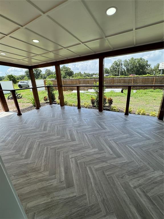 A covered porch features a herringbone-patterned floor, wood-stained posts, and horizontal wood siding — 1119 N PARSONS AVENUE, SEFFNER, FL