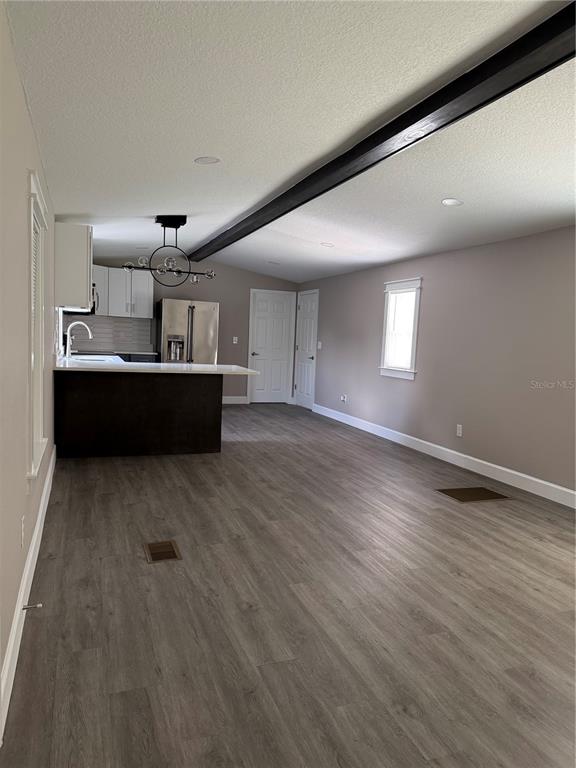 A kitchen features white upper cabinets, gray lower cabinets, stainless steel appliances, and a peninsula — 1119 N PARSONS AVENUE, SEFFNER, FL