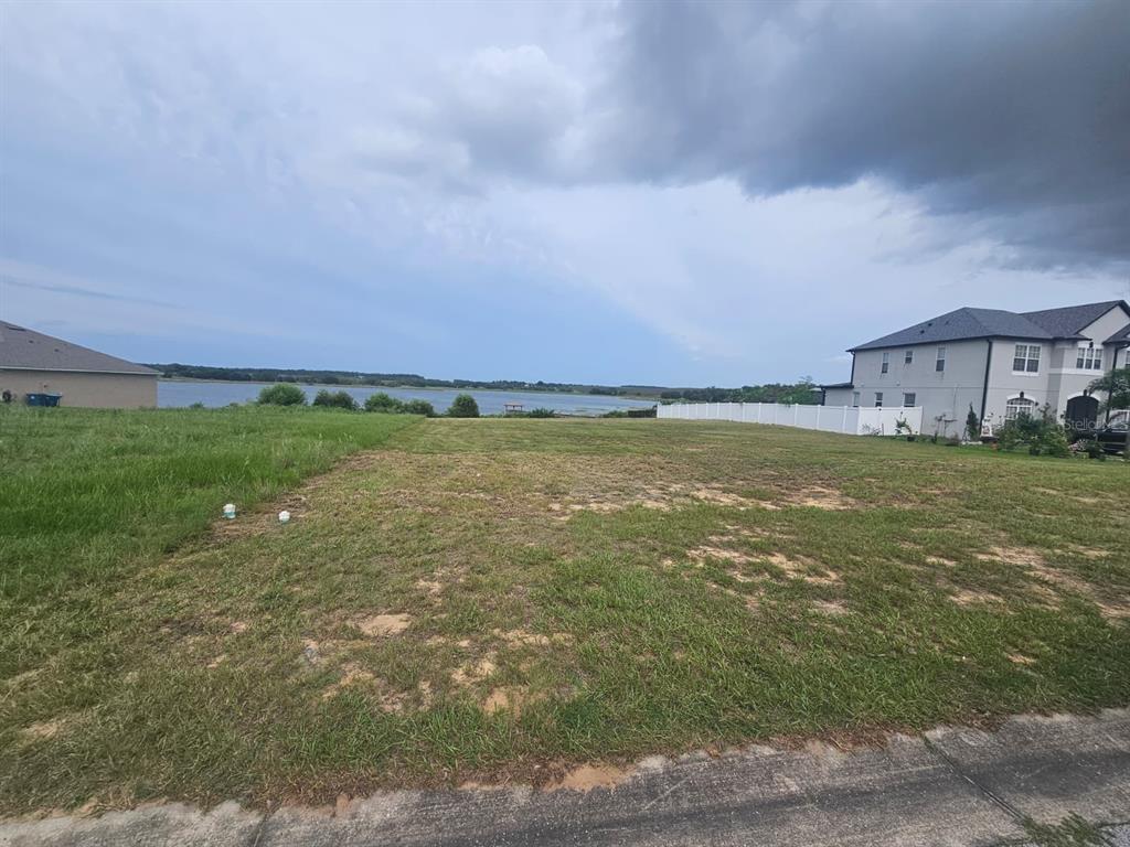 A vacant grassy lot overlooks a lake under a cloudy sky — 4712 BROOKSHIRE COURT, LAKE WALES, FL